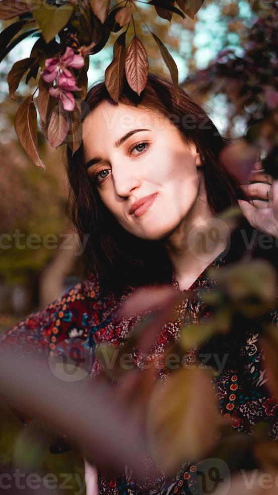 Beautiful young woman in burgundy leaves photo