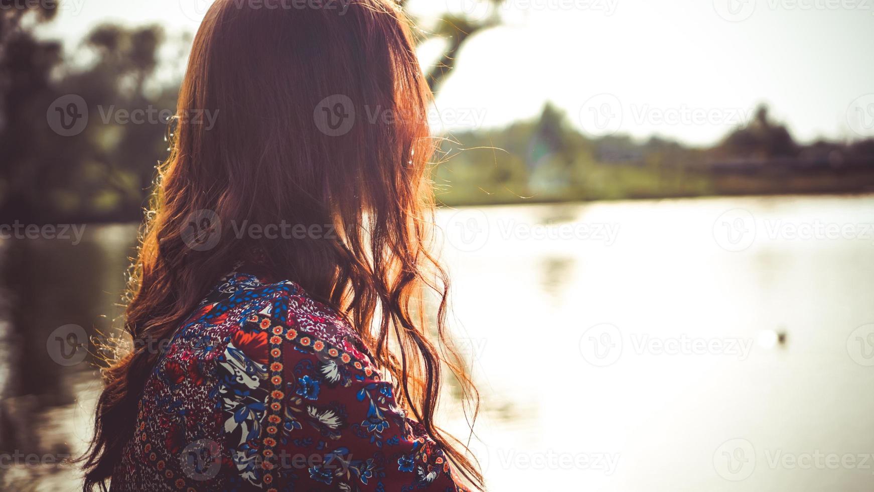 Back of woman resting on the nature near the river photo