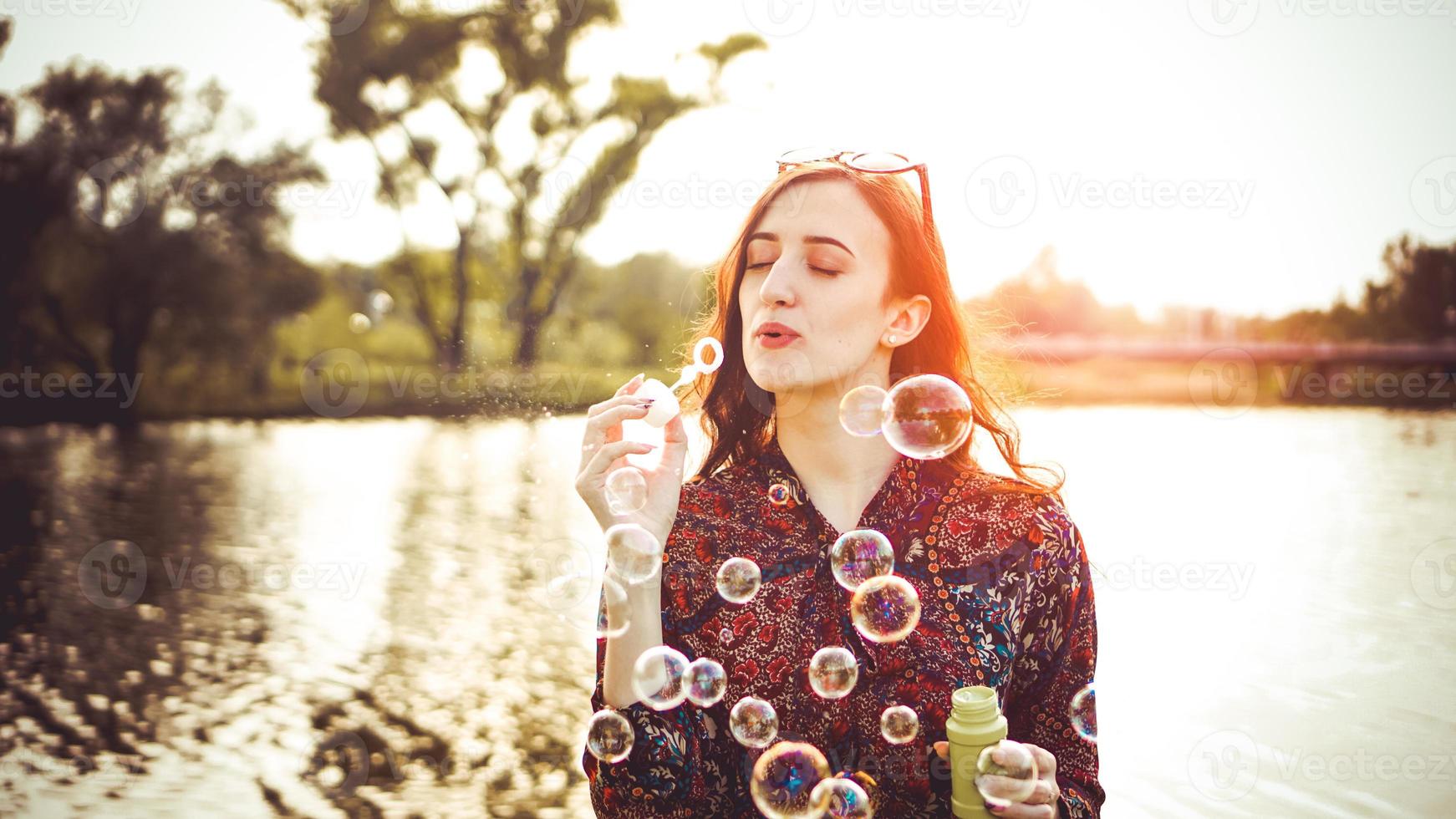 Romantic portrait of young woman with soap balloons. photo