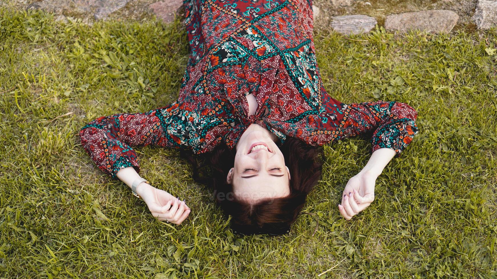 Young woman lying on grass. People relaxing in outdoors. photo
