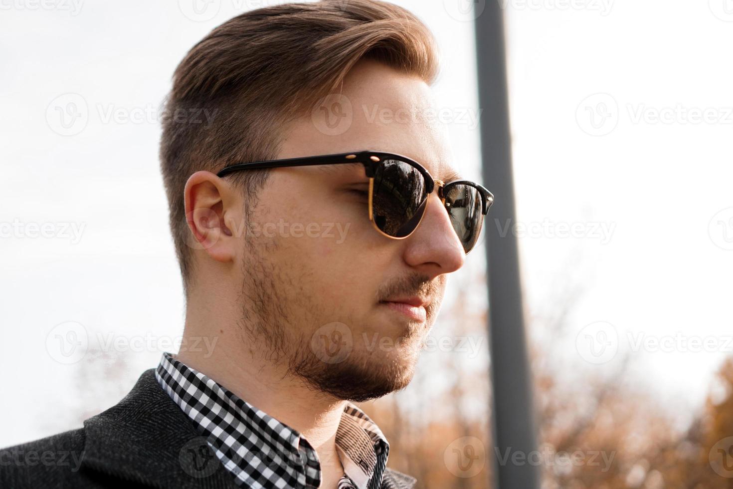 Outdoors portrait of young man with sunglasses photo