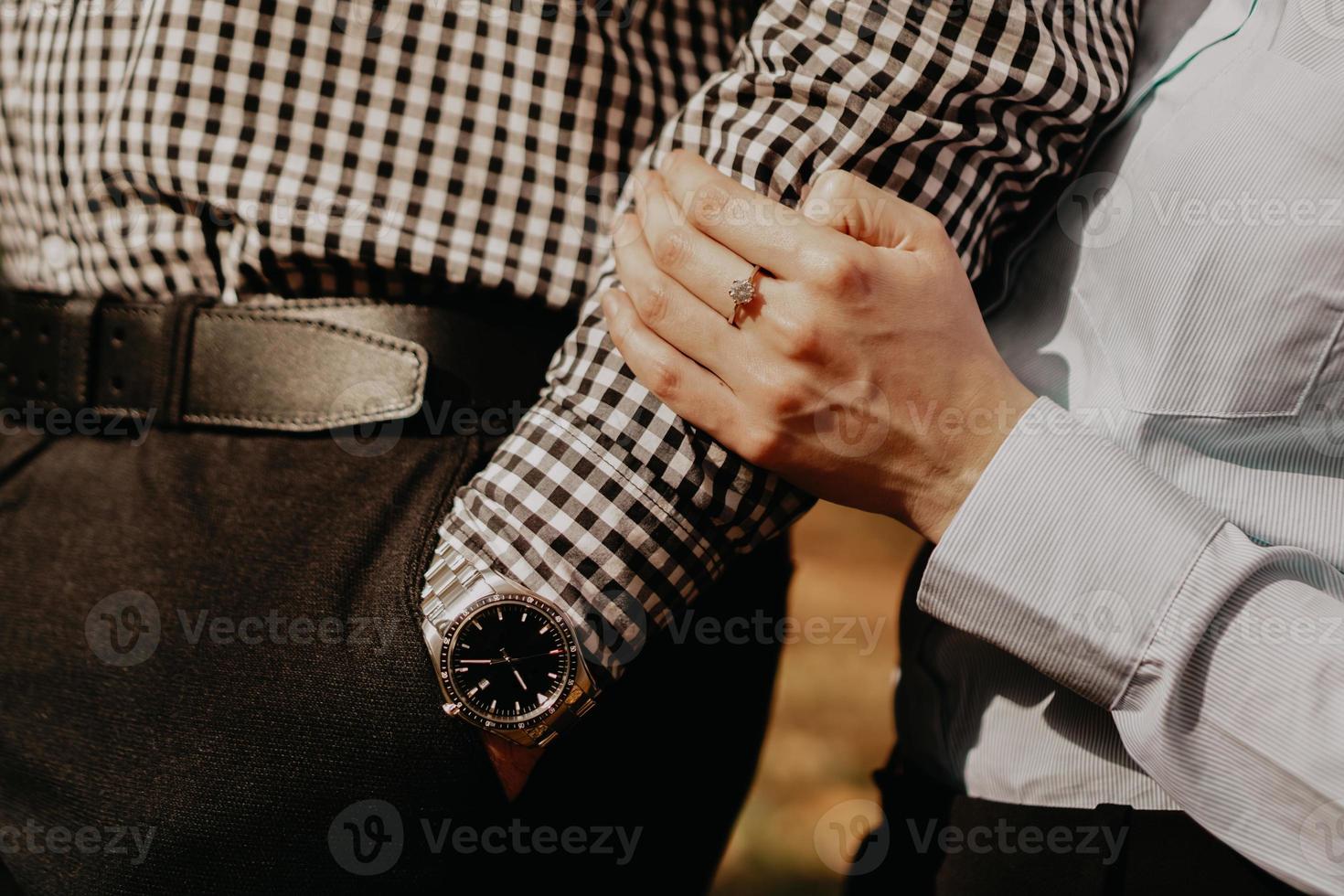 Couple of lovers holding hands. Hand with wrist watch. photo