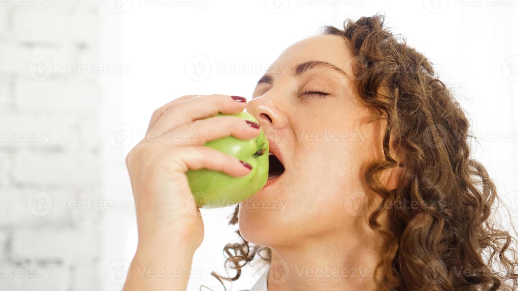 mujer comiendo saludable mordiendo una manzana verde foto