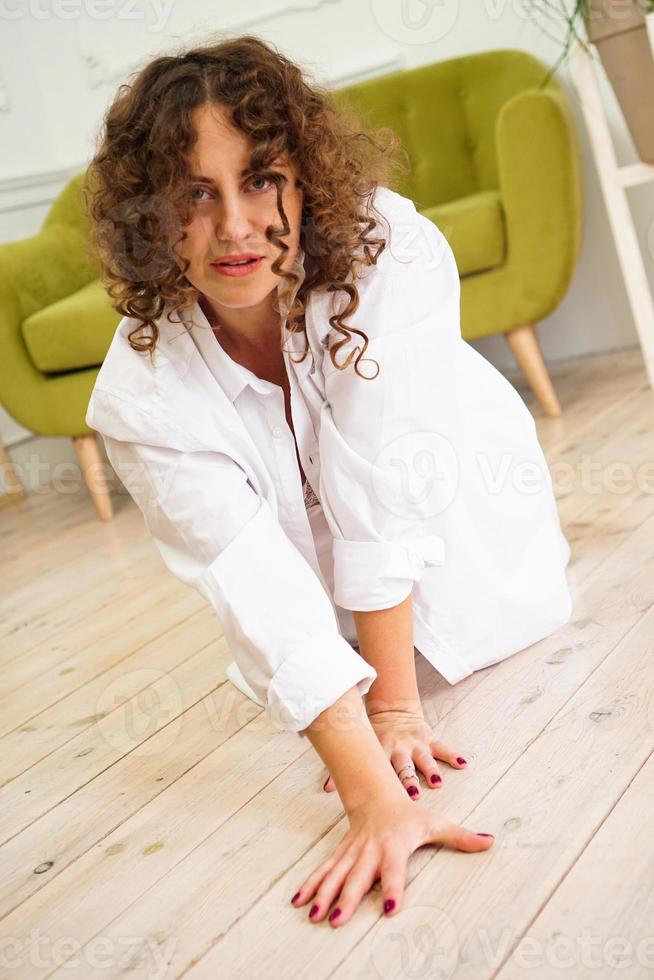 sexy, mujer, en, camisa blanca, en, piso de madera foto