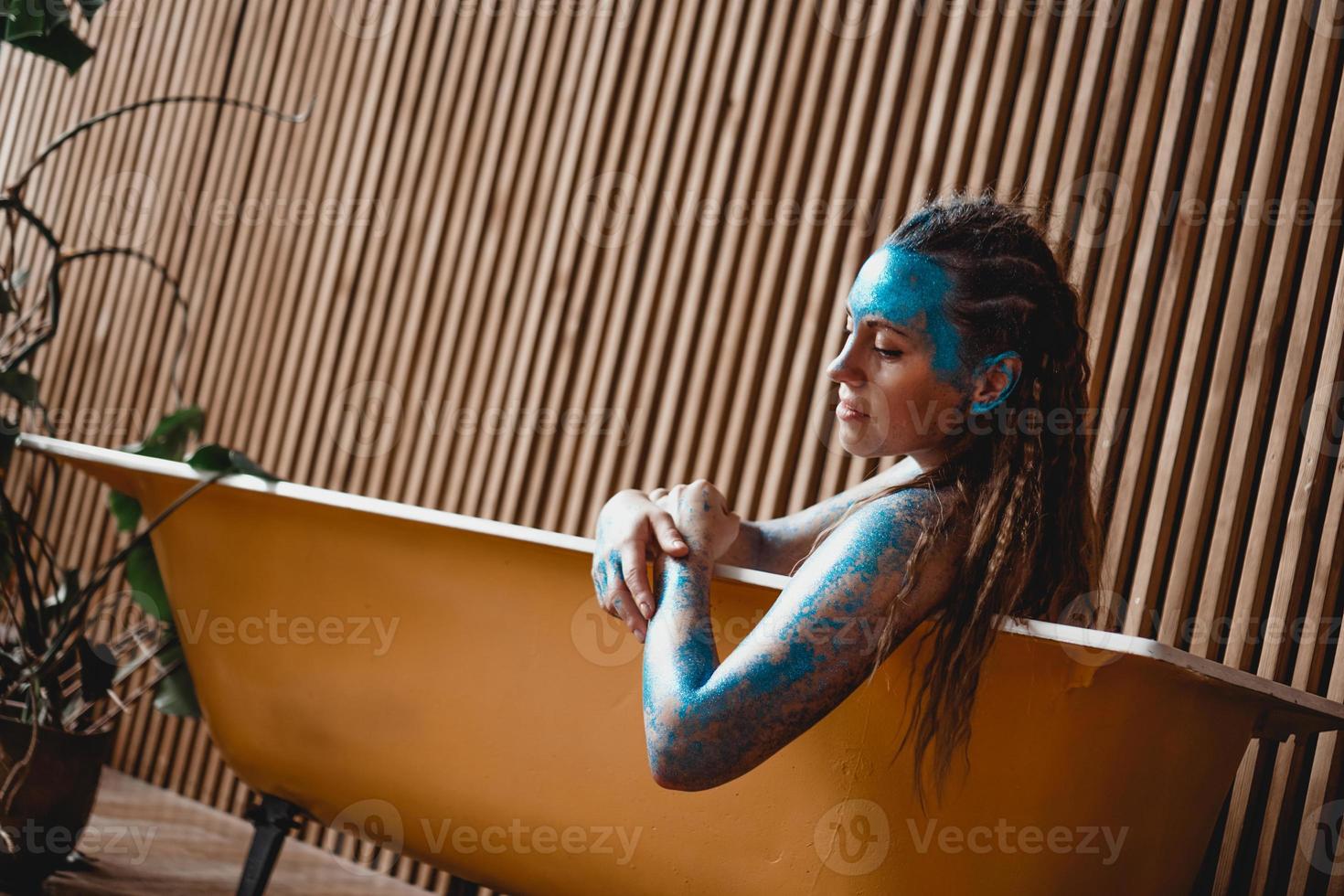 Woman with sparkles on her face. Girl in the bath photo