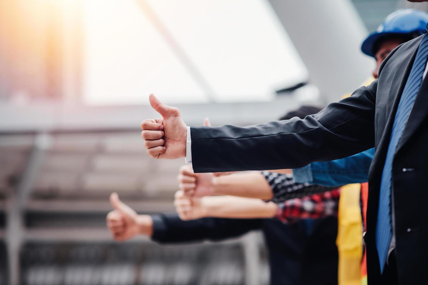 Cerca del alegre grupo empresarial dando Thumbs up foto