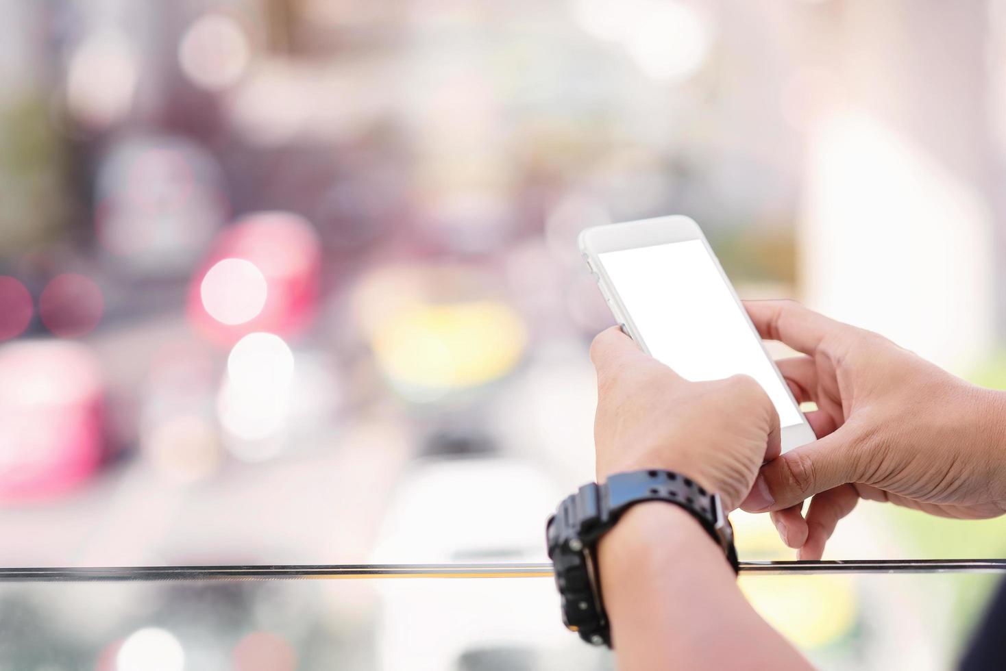 Cerca de la mano del hombre mediante teléfono móvil en la calle foto