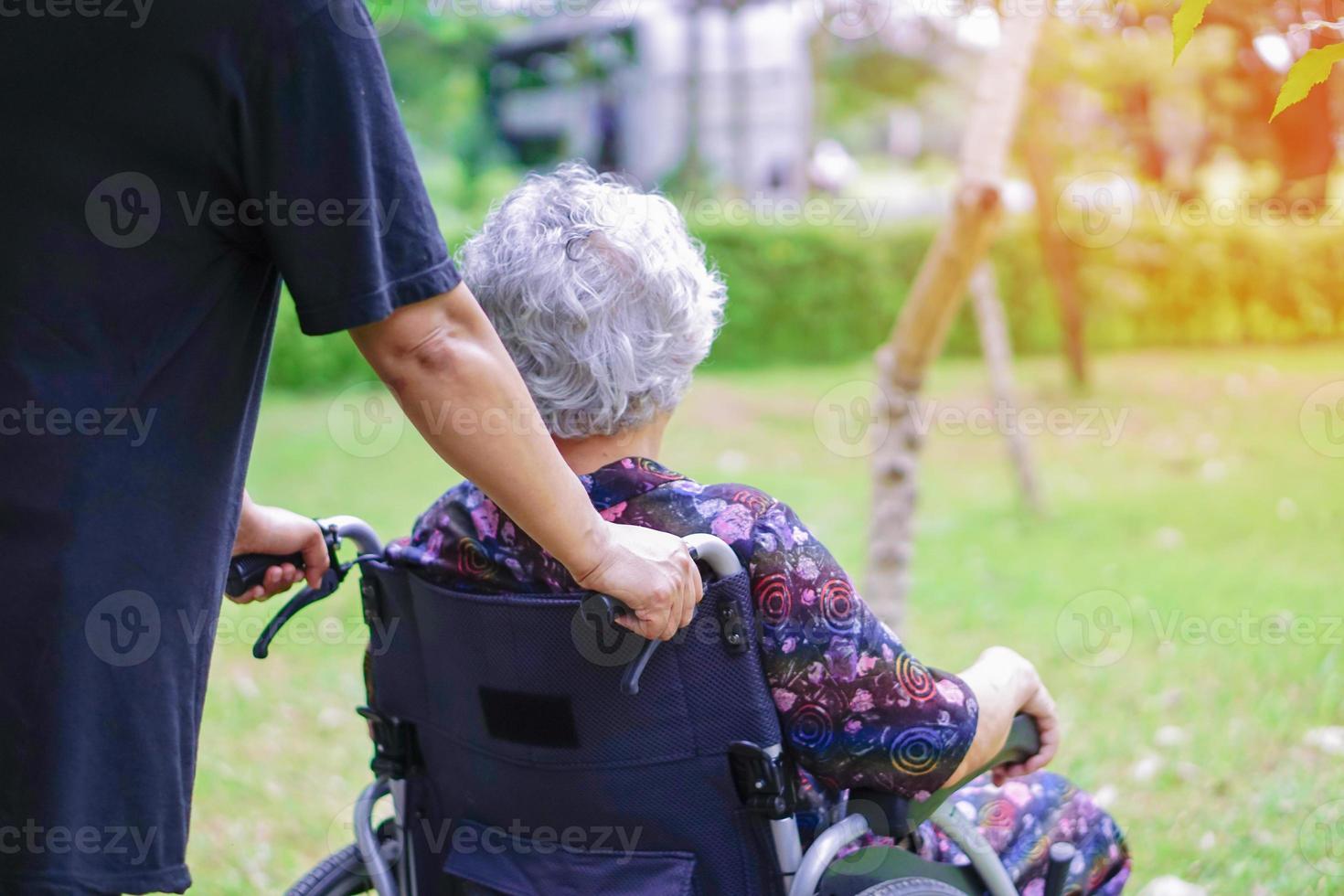 Help and support asian senior woman patient sitting on wheelchair photo