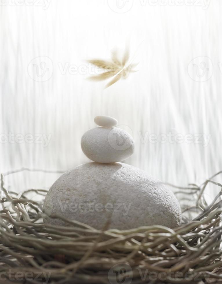 Un montón de tres piedras blancas aisladas en un nido de pájaro foto