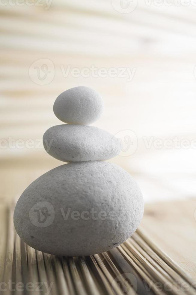 A pile of three white stones isolated in blurred background photo