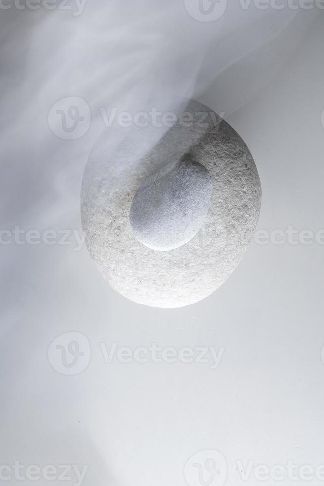 Top view of two white pebble stone on white surface. photo