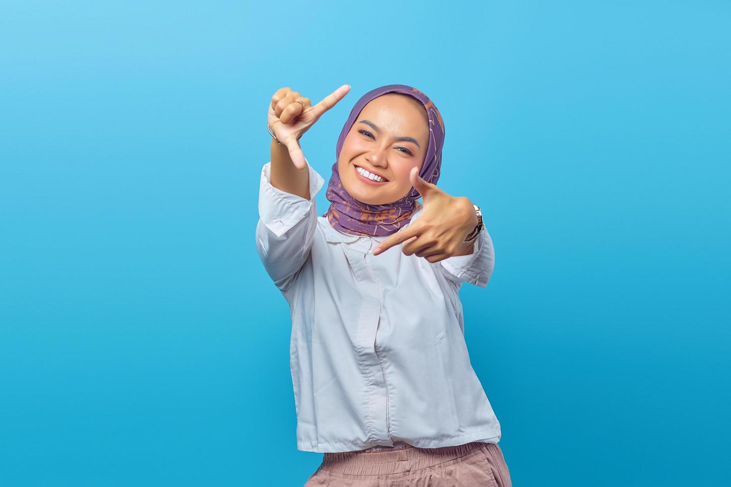 Asian woman looking at camera with hands making selfie photo