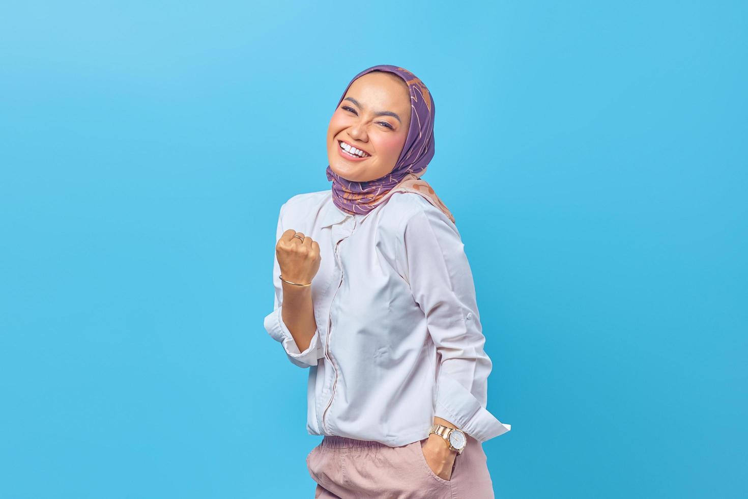 Cheerful young Asian woman raising her fist with smiling face happy photo