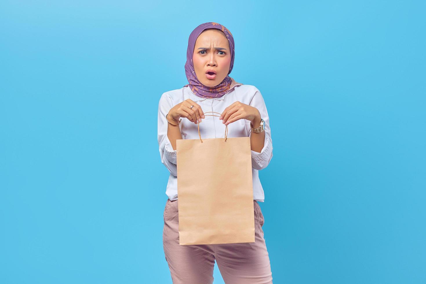 Portrait of surprised young student carrying shopping bags photo