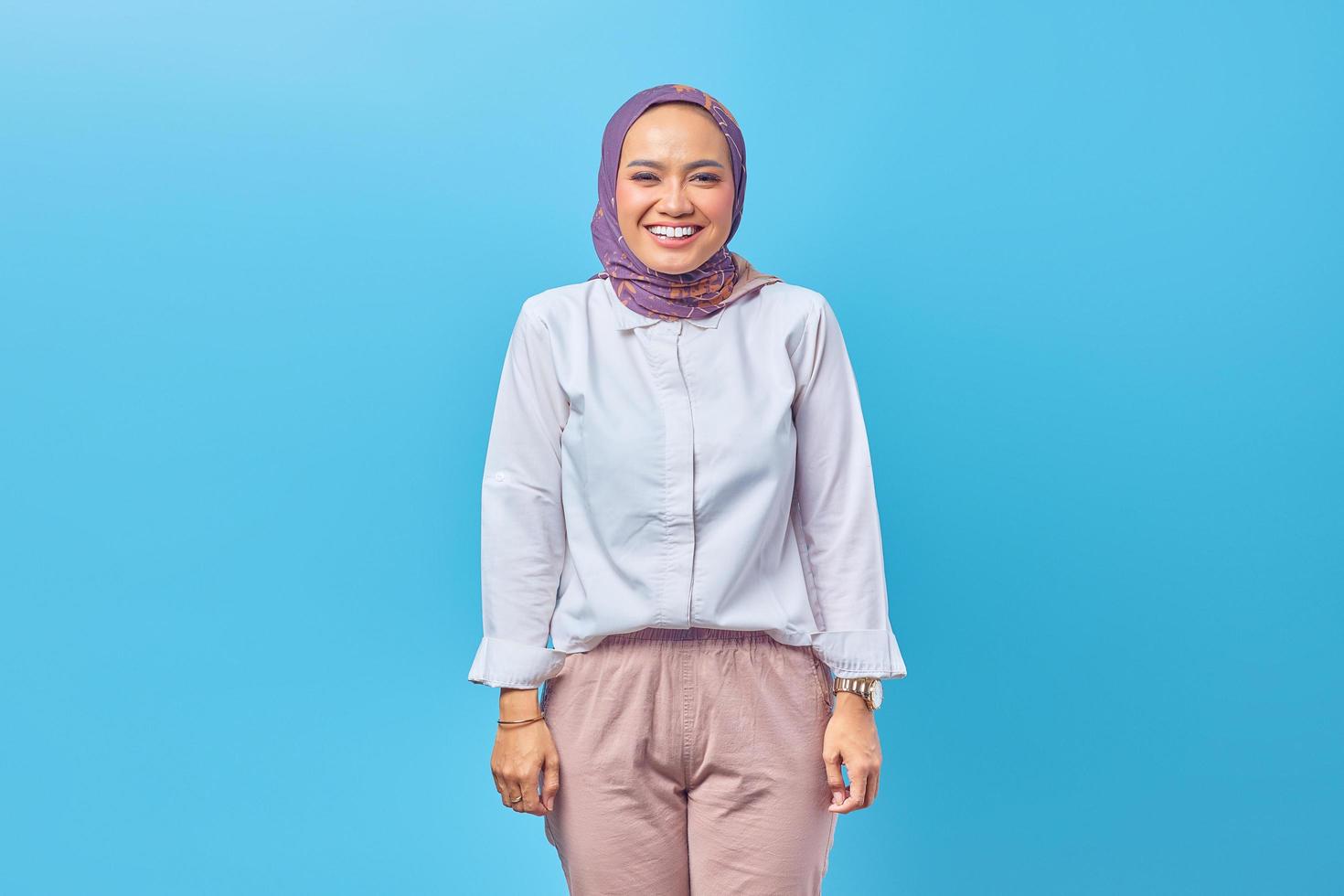 Hermosa mujer asiática sonriendo ampliamente aislado sobre fondo azul. foto