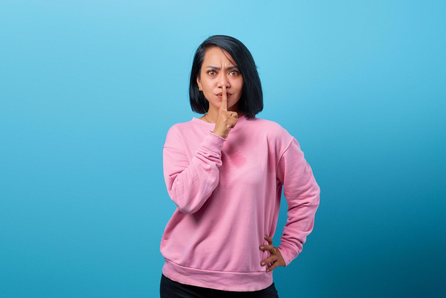 Portrait of beautiful Asian woman making silent gesture photo