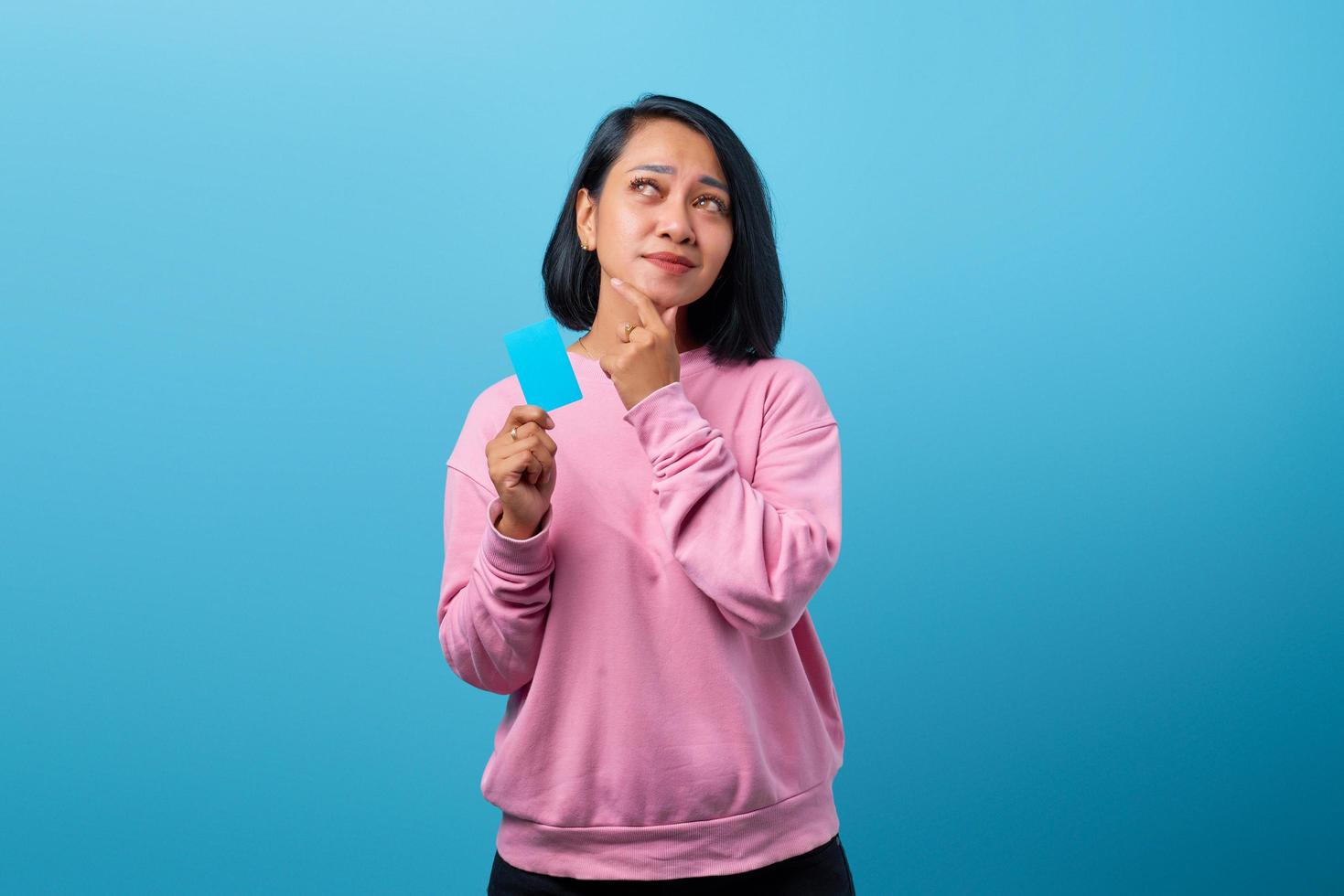 Portrait of woman holding credit card looking sideways photo