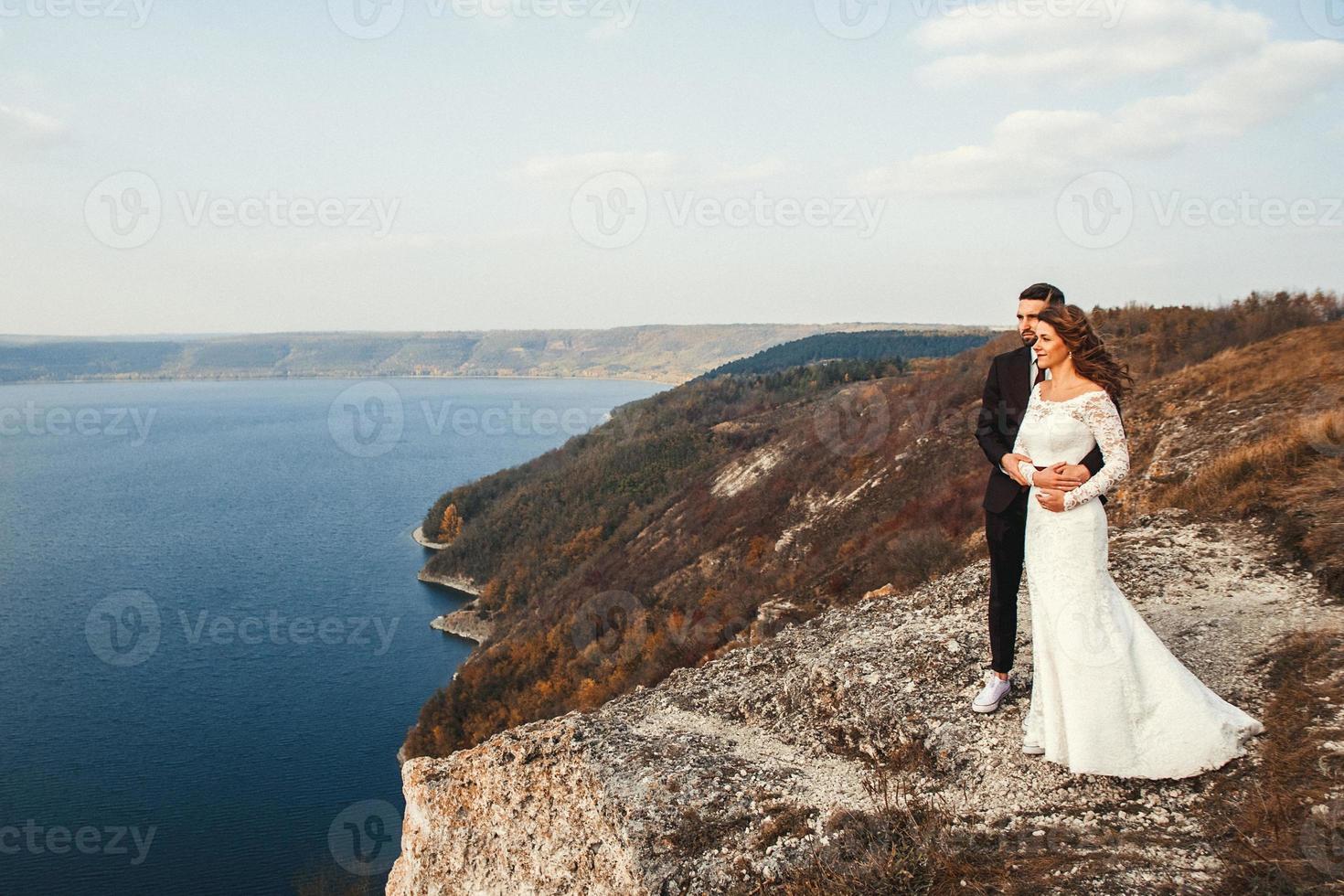 Married couple holding hands on a mountain photo