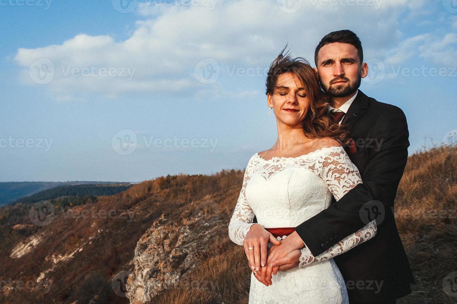 Married couple holding hands on a mountain photo