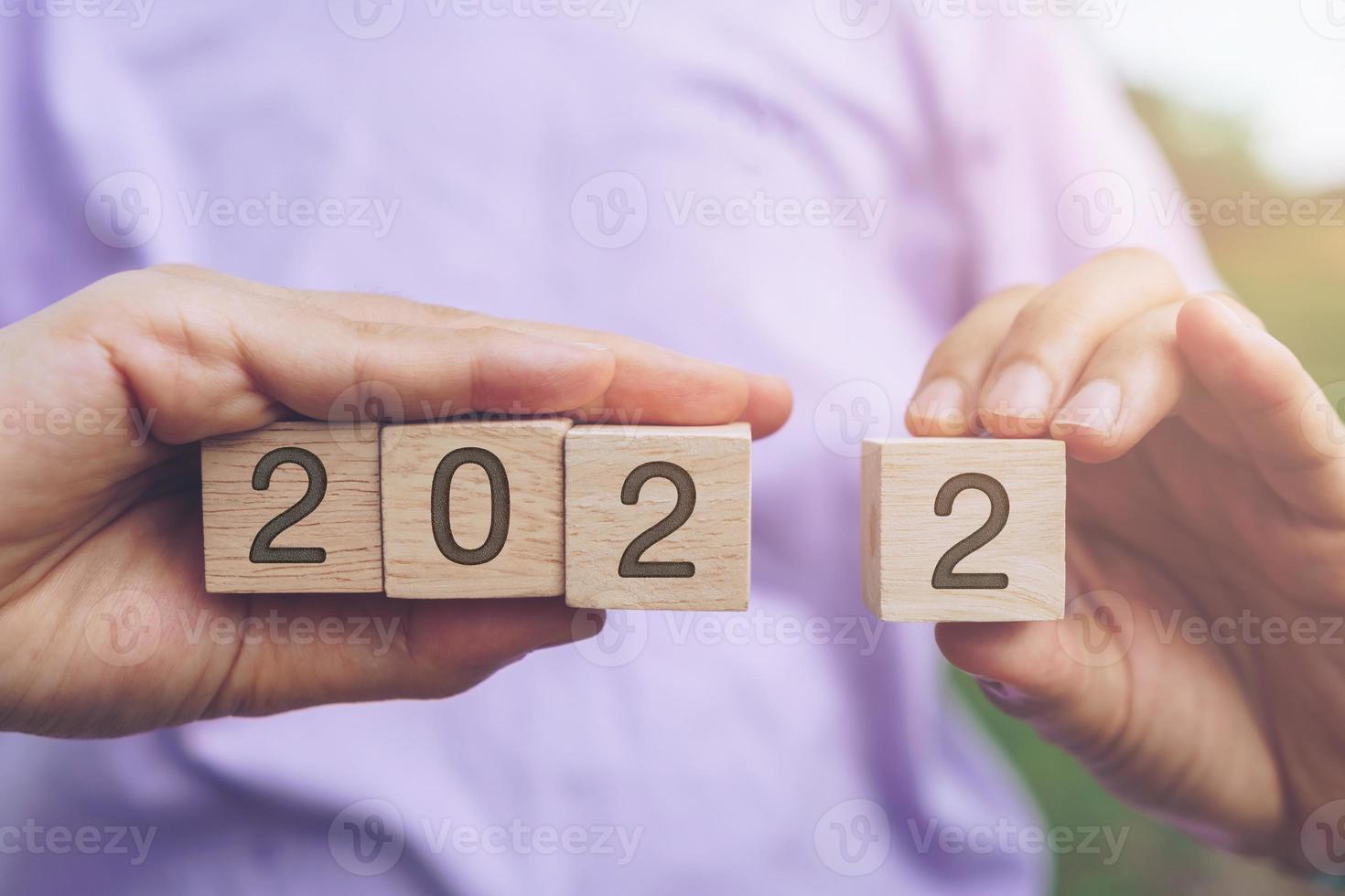 Hand hold wooden cubes 2022 background, copy space. Goal concept. photo