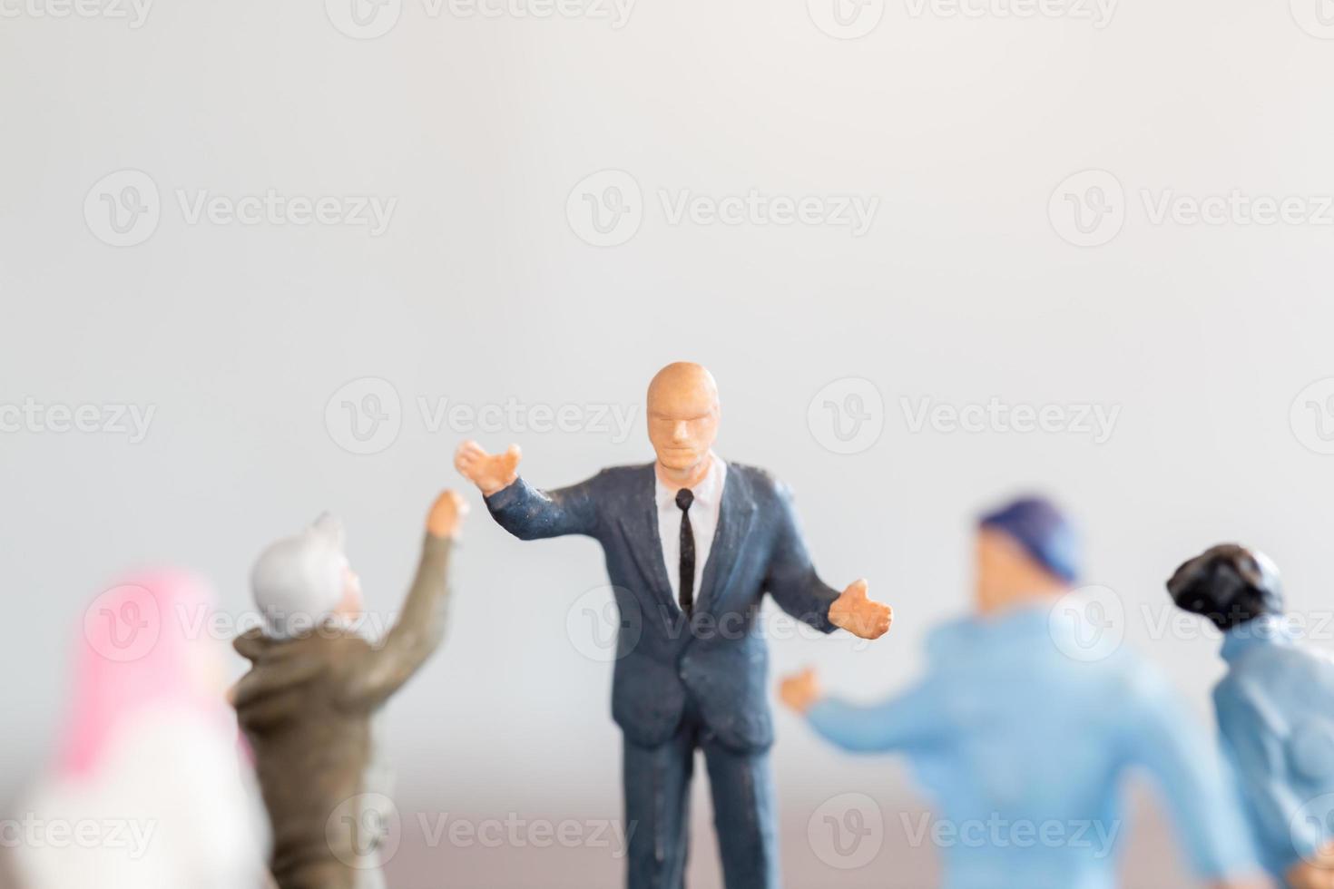 Estudiantes de personas en miniatura de pie con el profesor en el aula. foto