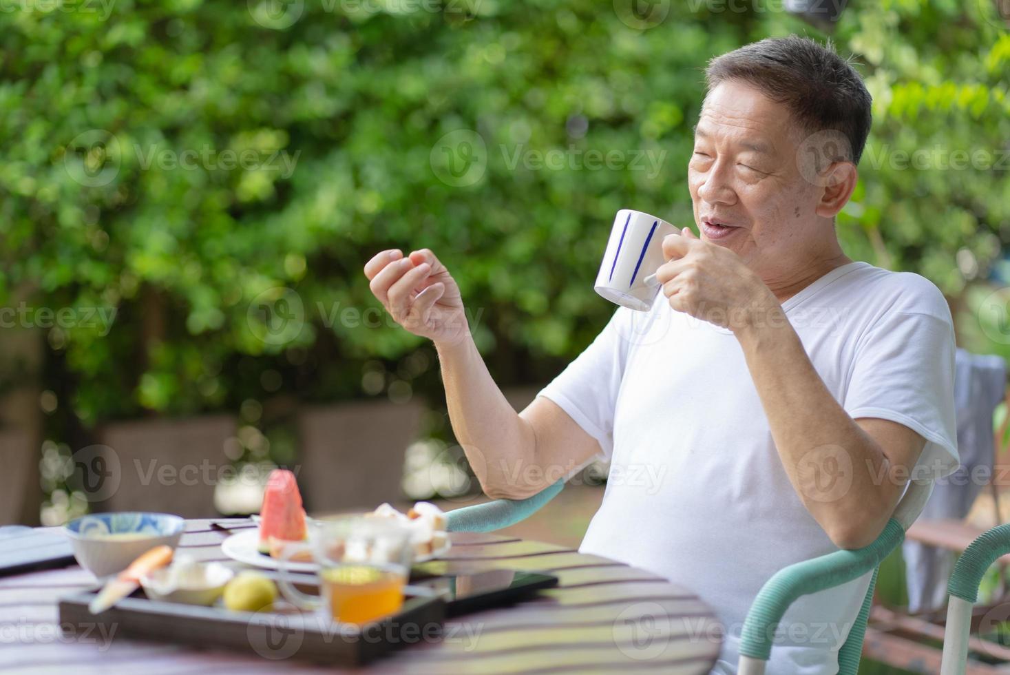 Hombre maduro comiendo un desayuno saludable en el jardín foto