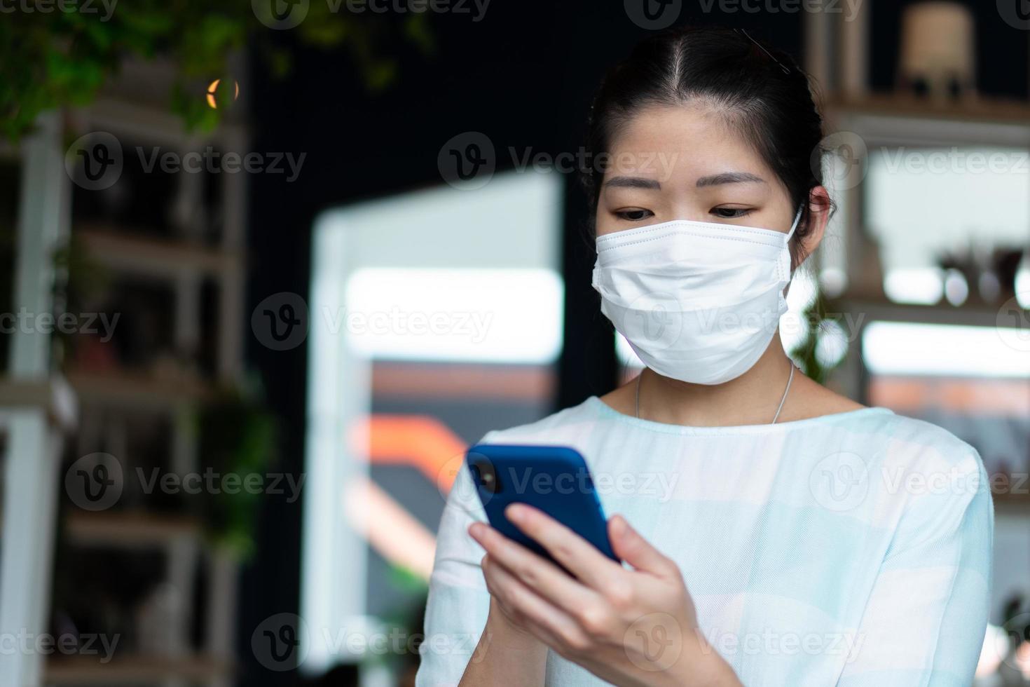 Masked woman checking phone photo