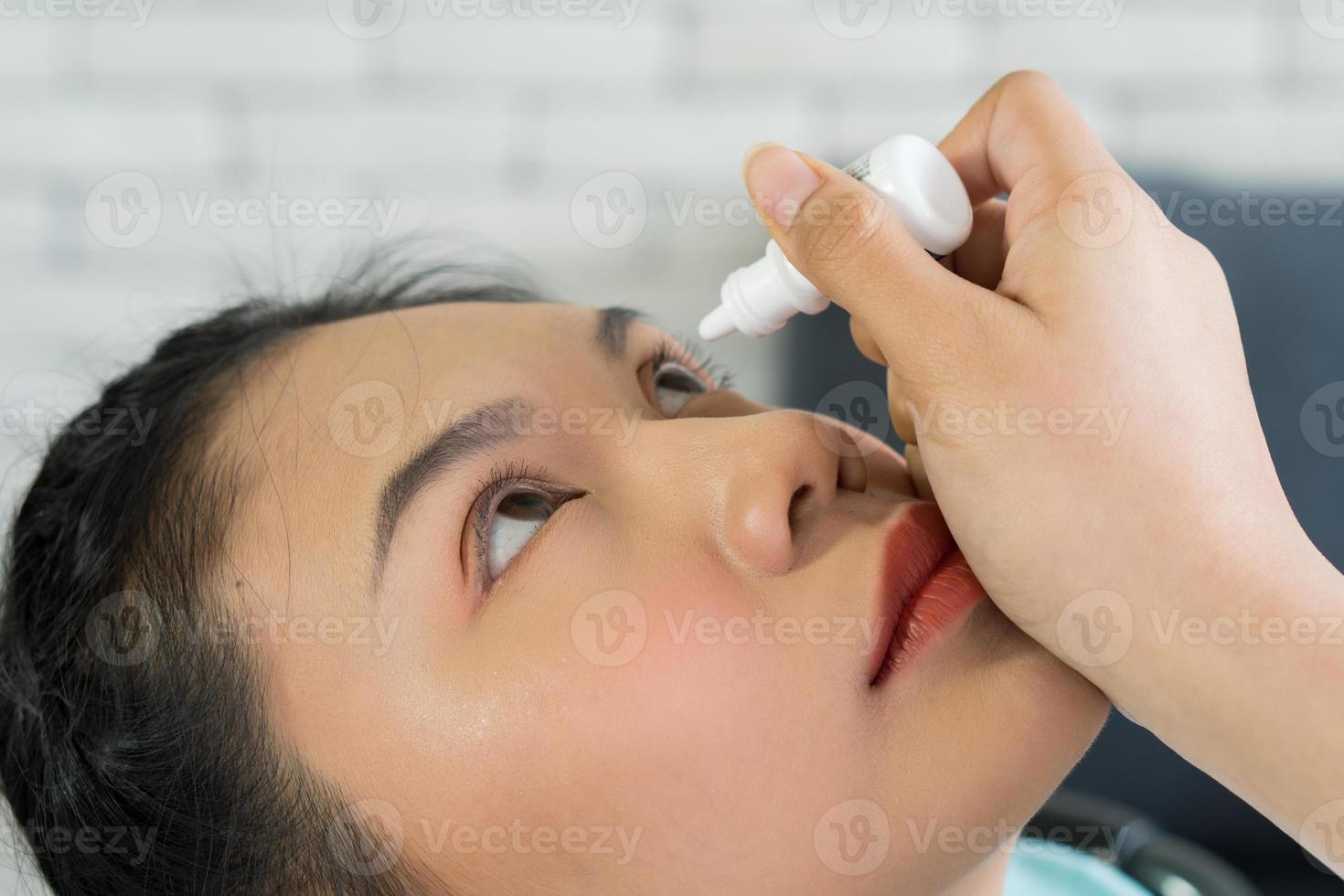 mujer usando gotas para los ojos foto