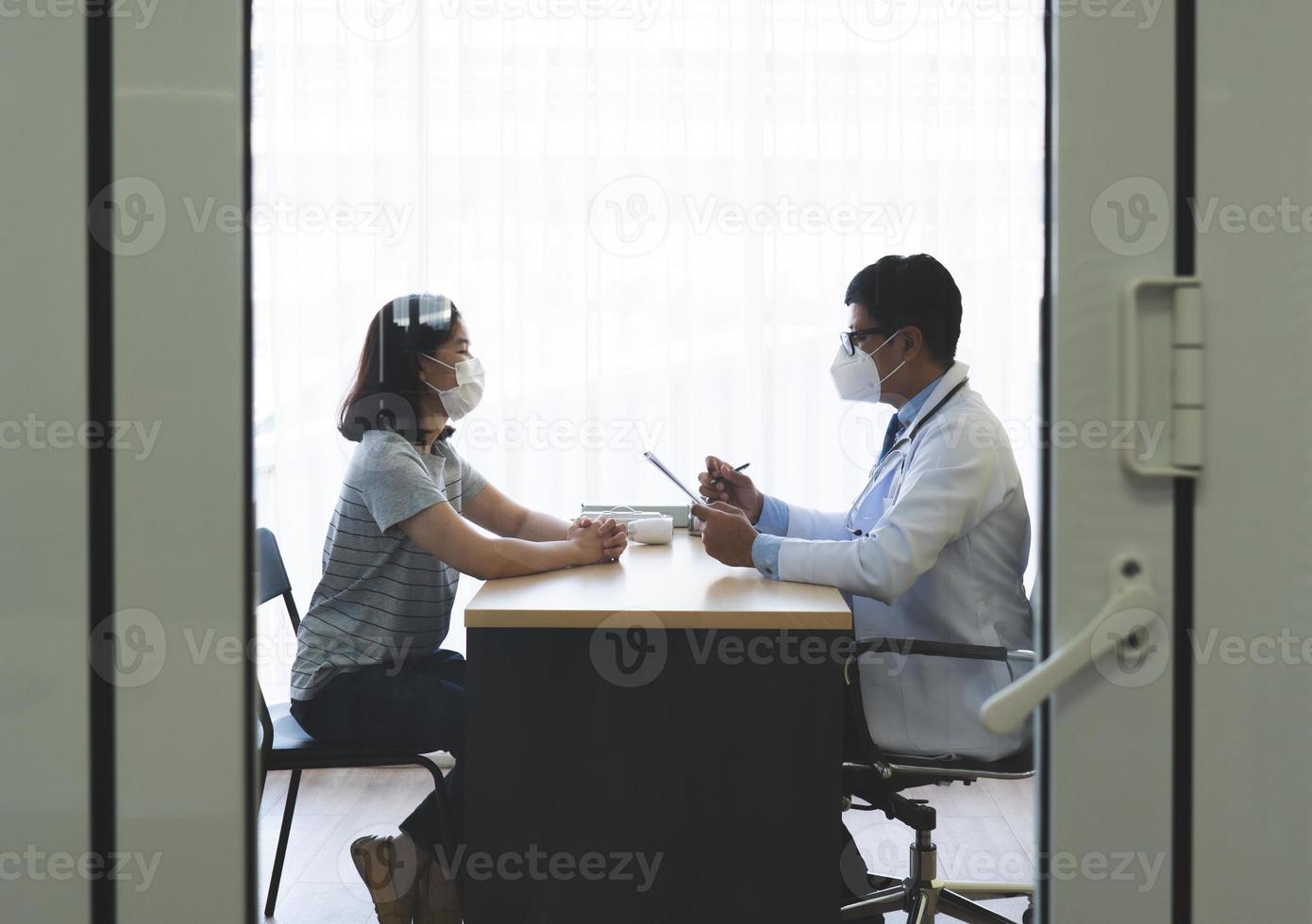 Doctor talking to patient with masks on photo