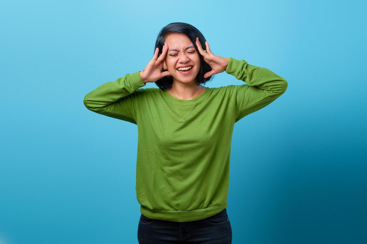 Frustrated confused Asian woman keeping hands in her hair photo
