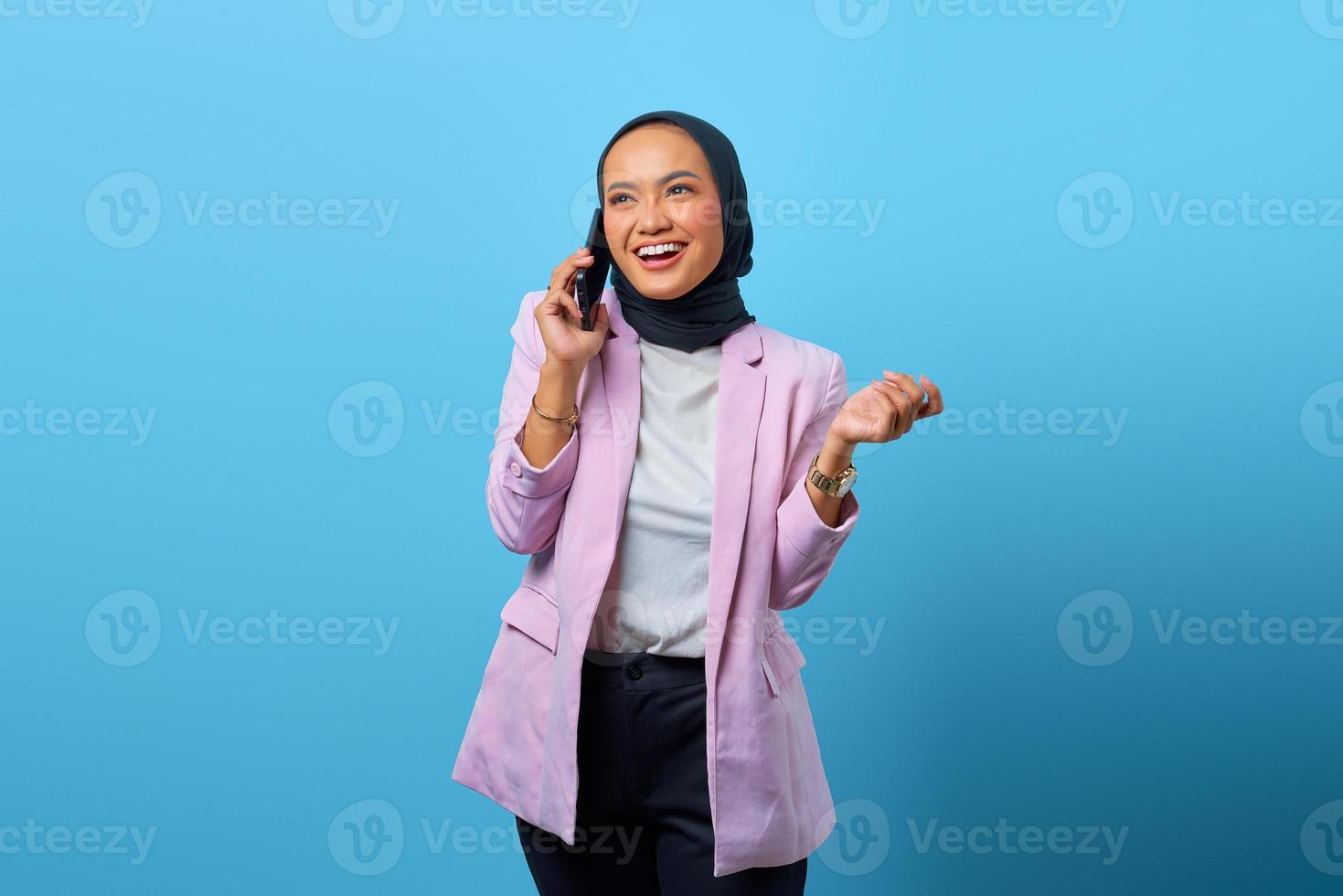 Cheerful Asian woman talking with friend by mobile phone photo