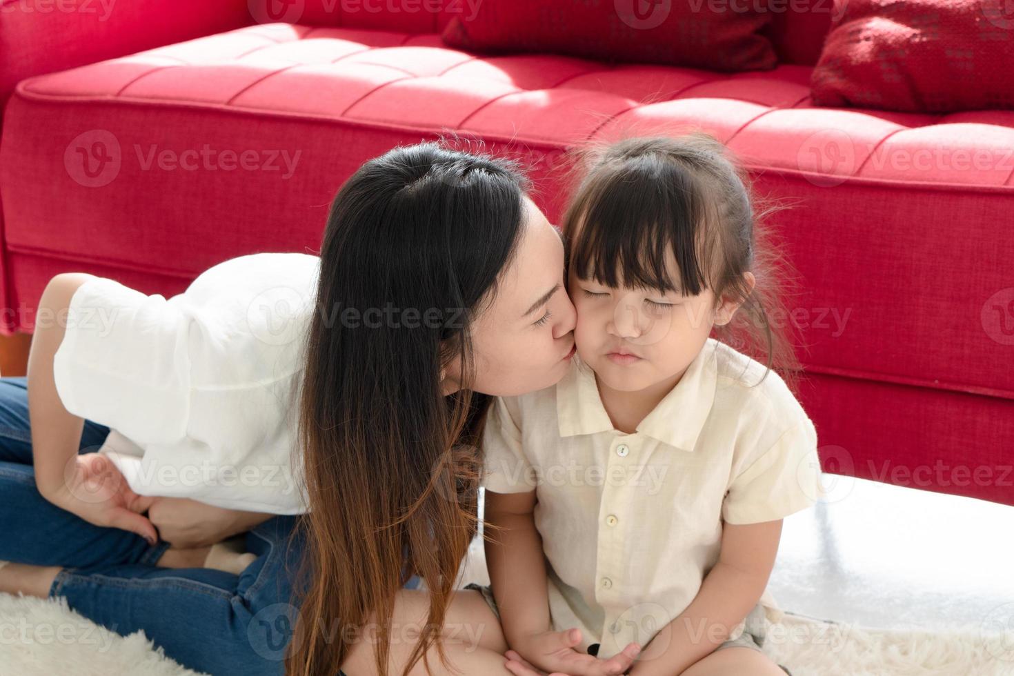 Mother kissing daughter photo