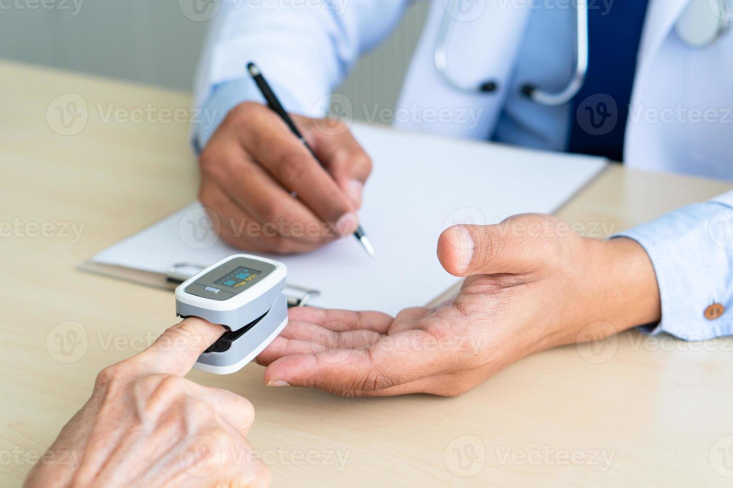 Médico midiendo la saturación de oxígeno del paciente. foto