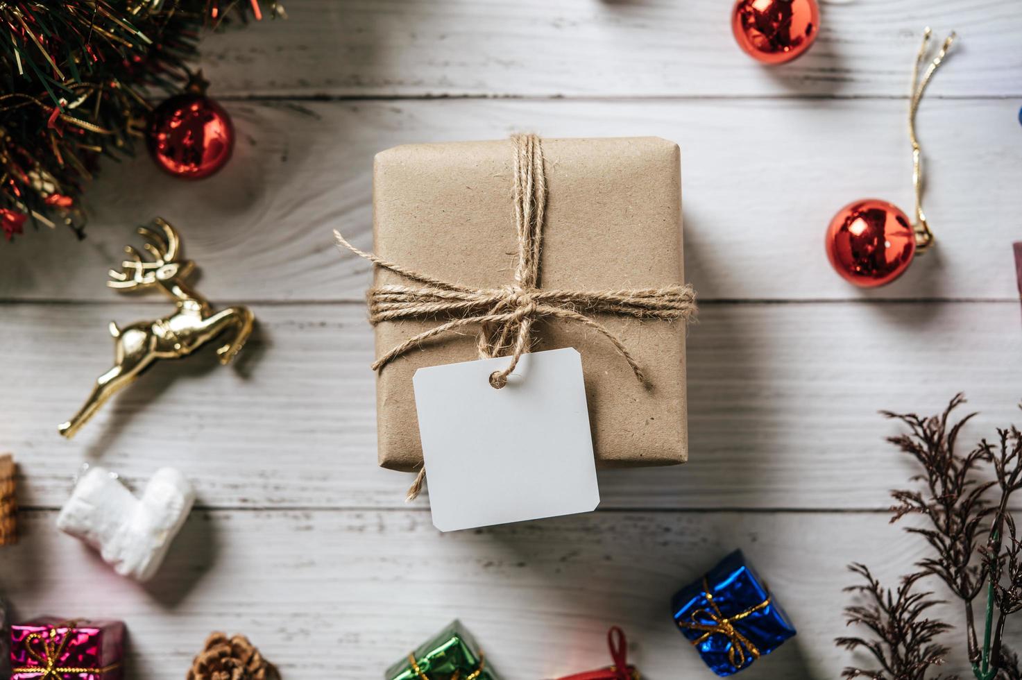 Caja de regalo con un pequeño regalo sobre un fondo de madera blanca foto