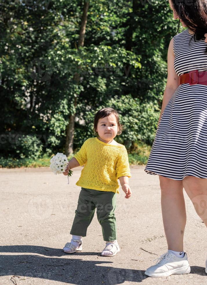 Feliz familia multirracial de madre e hija caminando en el parque foto