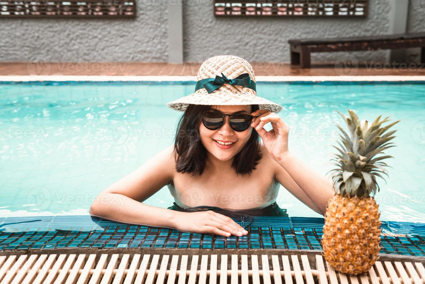 mujer en traje de baño se está relajando en la piscina foto