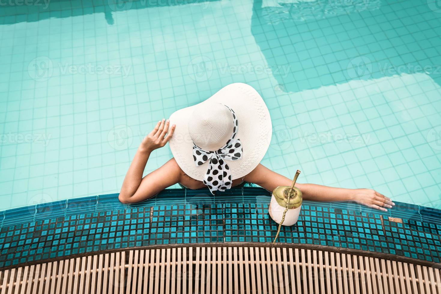 mujer en traje de baño se está relajando en la piscina foto