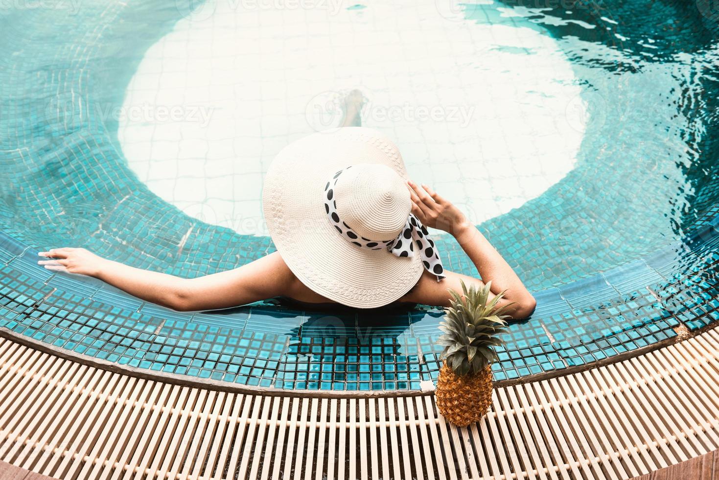 mujer en traje de baño se está relajando en la piscina foto