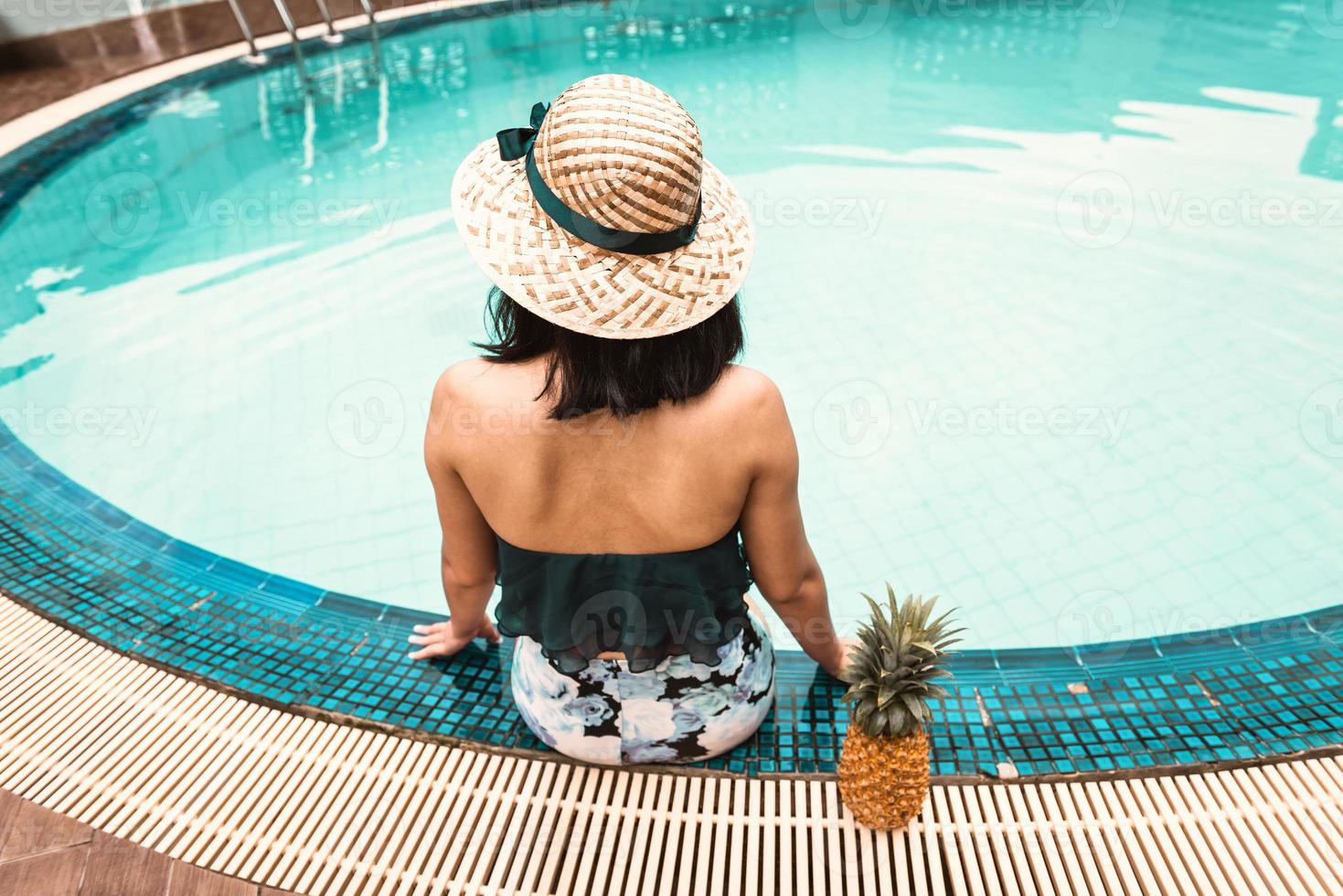 Rear View of Sexy Woman in Swimsuit Relaxing in Swimming Pool photo