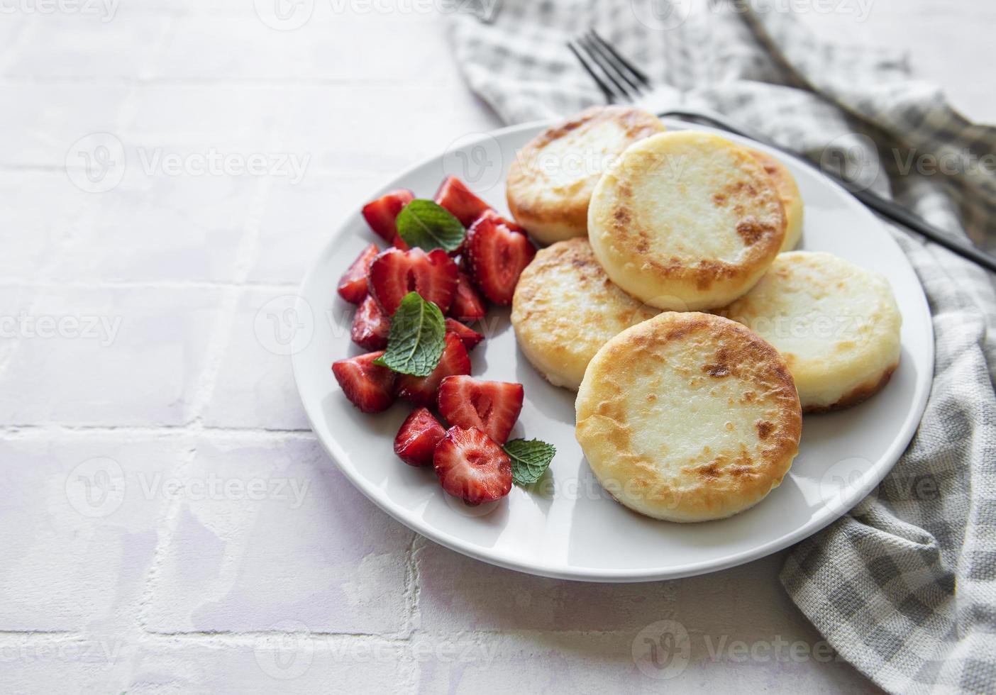 Tortitas de requesón, buñuelos de ricotta en placa de cerámica foto