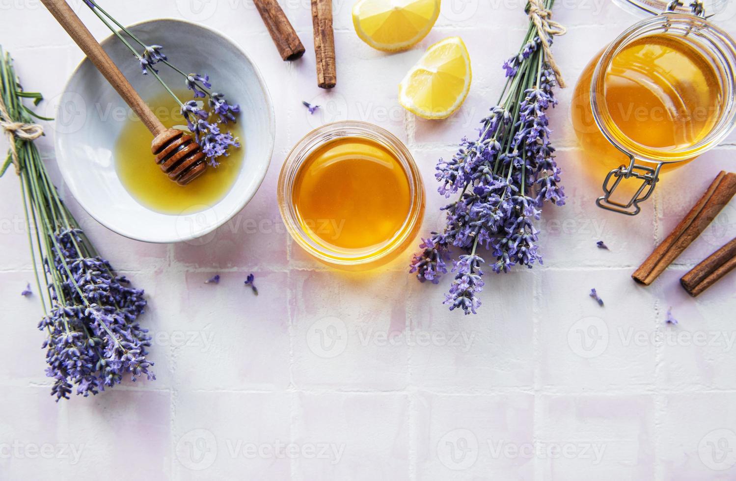 Jars and bowl with honey and fresh lavender flowers photo