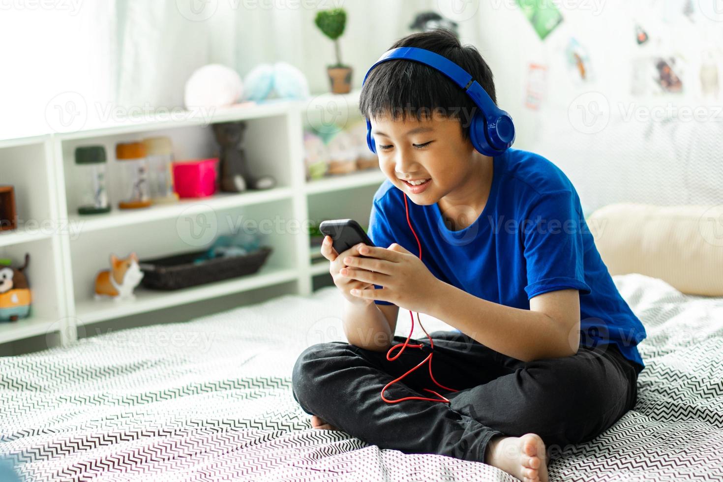 niño escuchando música en la cama en el dormitorio para relajarse foto