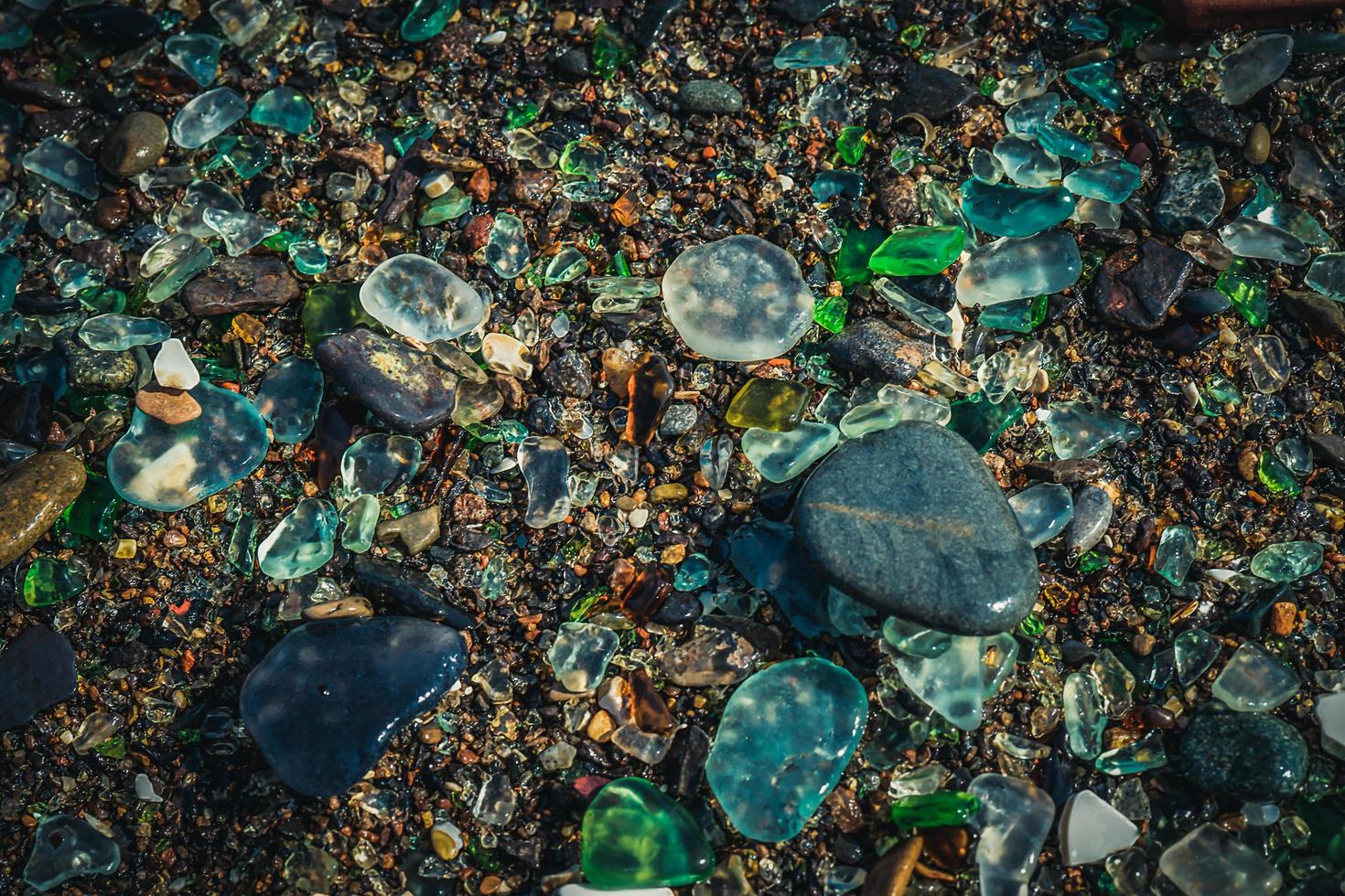 Natural background with sea glass close-up on sand. photo