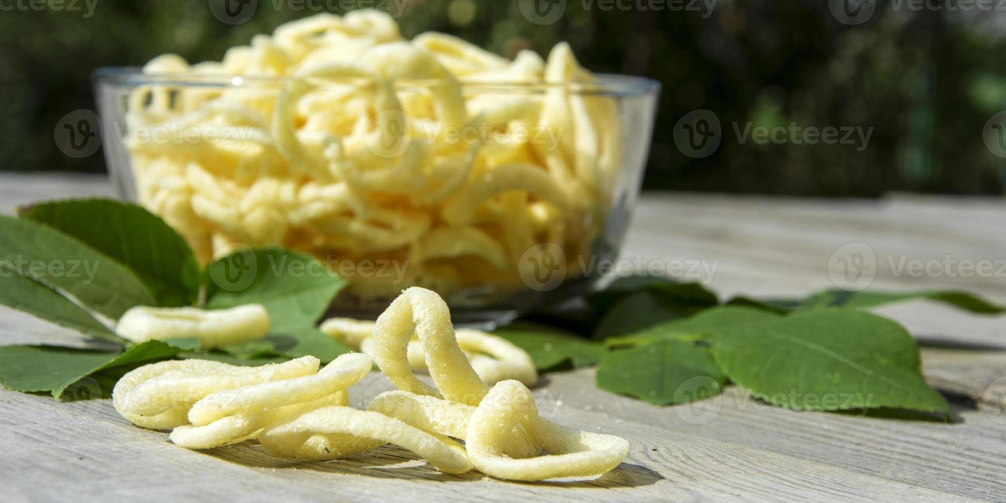 Onion rings close up. Chips in a glass dish on a wooden background photo