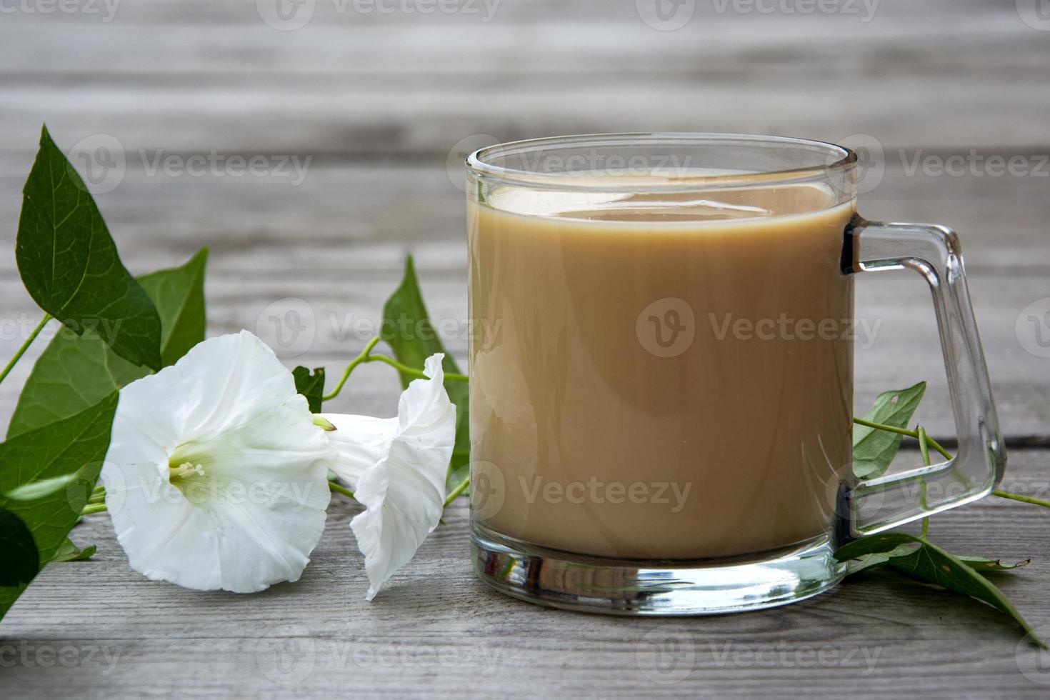 Mug with cocoa and loach with white flowers on a wooden background. photo