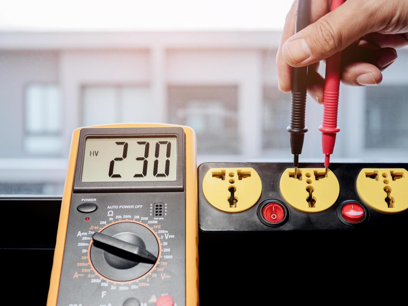 Measure the AC voltage of 230 Volts with a digital meter. photo