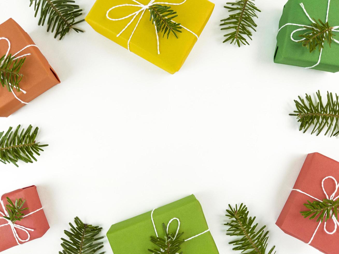 Holiday postcard with fir tree branches and gift boxes on a white photo