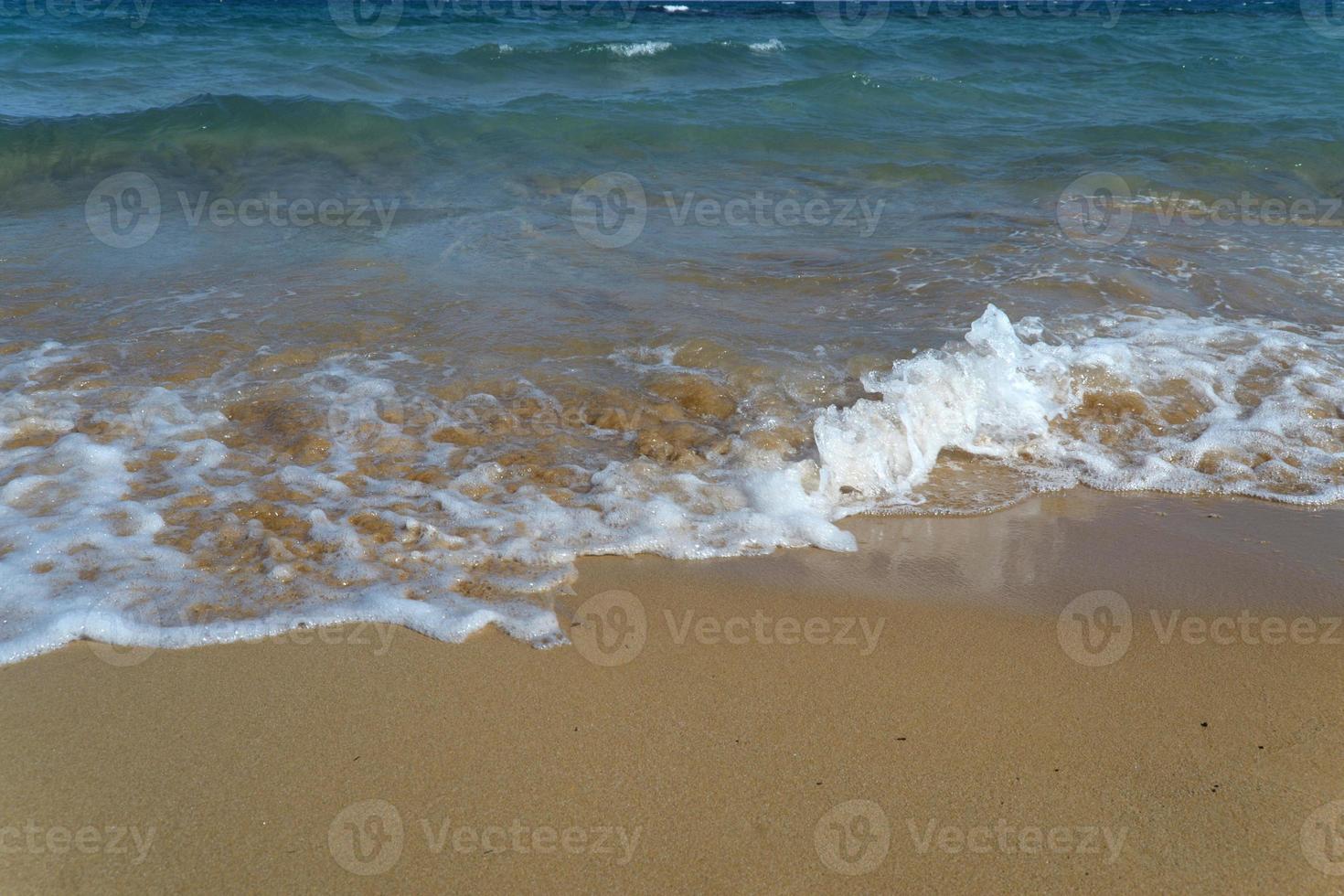 ola espumosa en la playa de arena. hermosa ola en la playa. foto