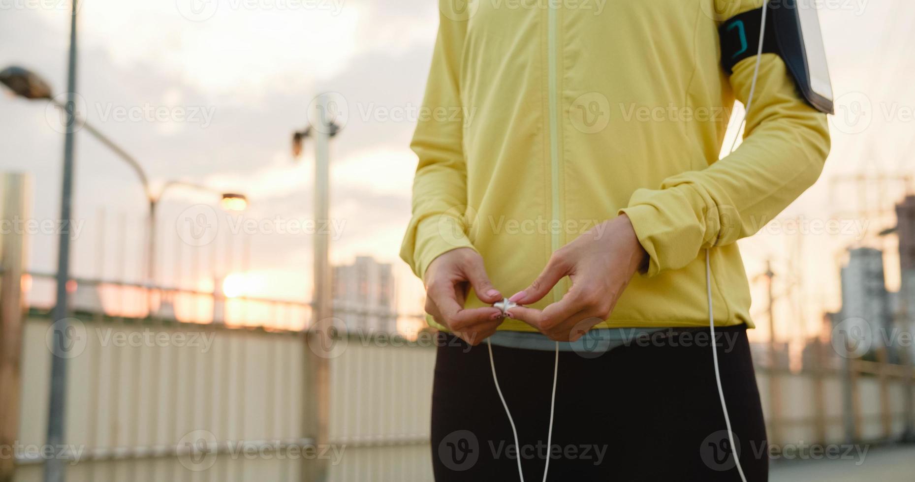 Asia atleta dama ejercicios con teléfono inteligente para escuchar música. foto