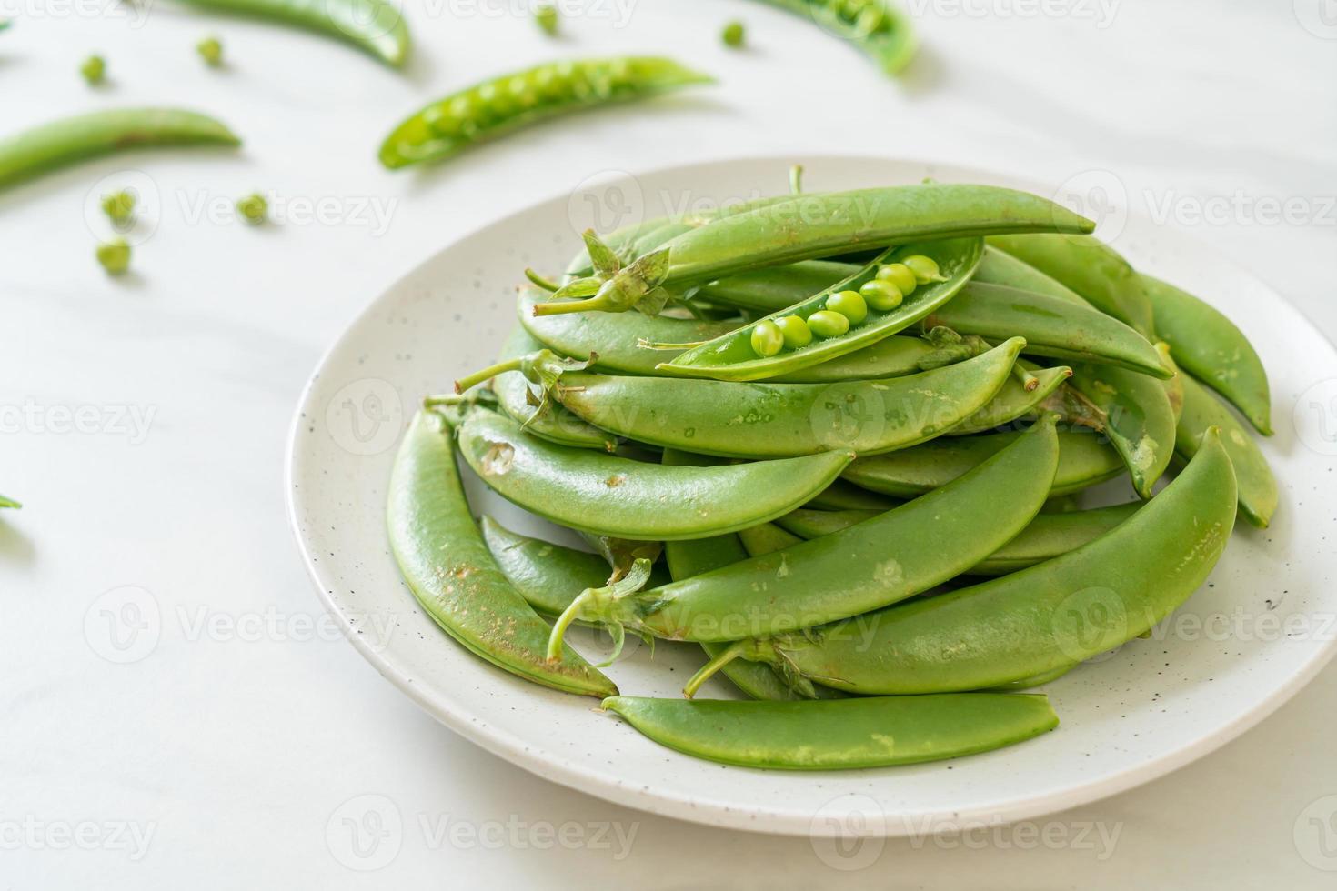 guisantes verdes dulces frescos en un plato foto